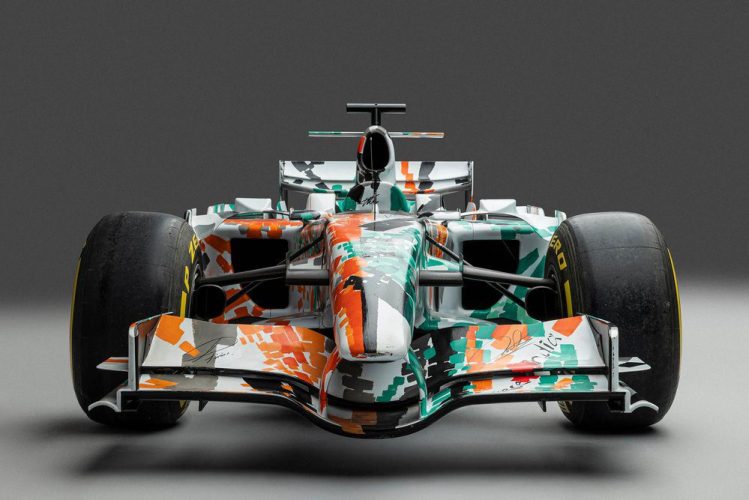 The 2008 Force India VJM01 art car, featuring a green, white, and orange livery designed by Dexter Brown, on display at the Goodwood Festival of Speed.