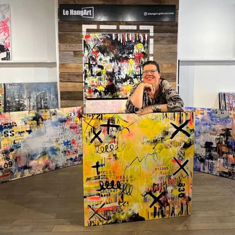 Lorette C. Luzajic in her studio surrounded by her eclectic artwork, embodying her dynamic and multifaceted approach to contemporary art.